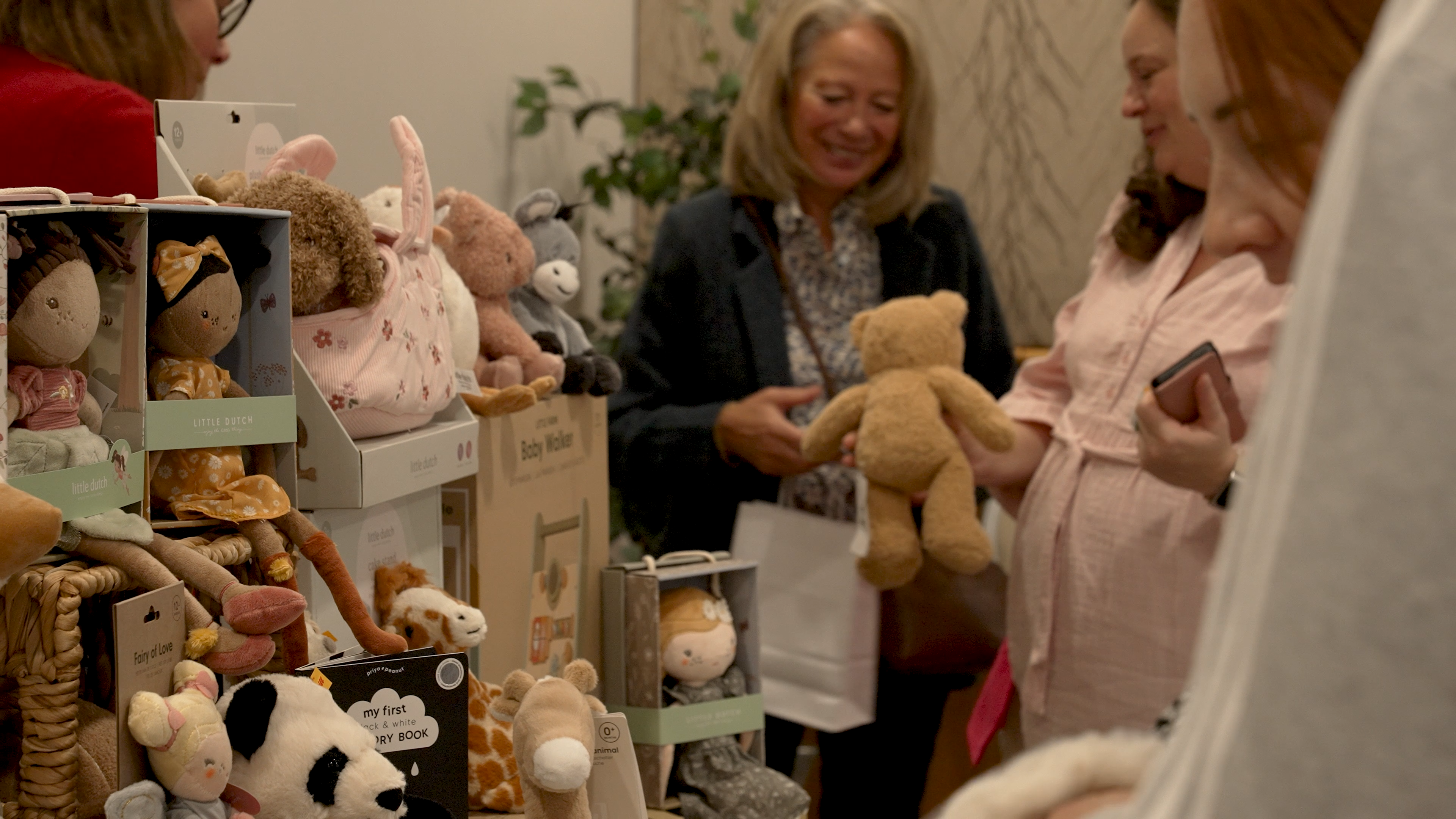 People shopping for stuffed animals in a store with shelves filled with various plush toys.